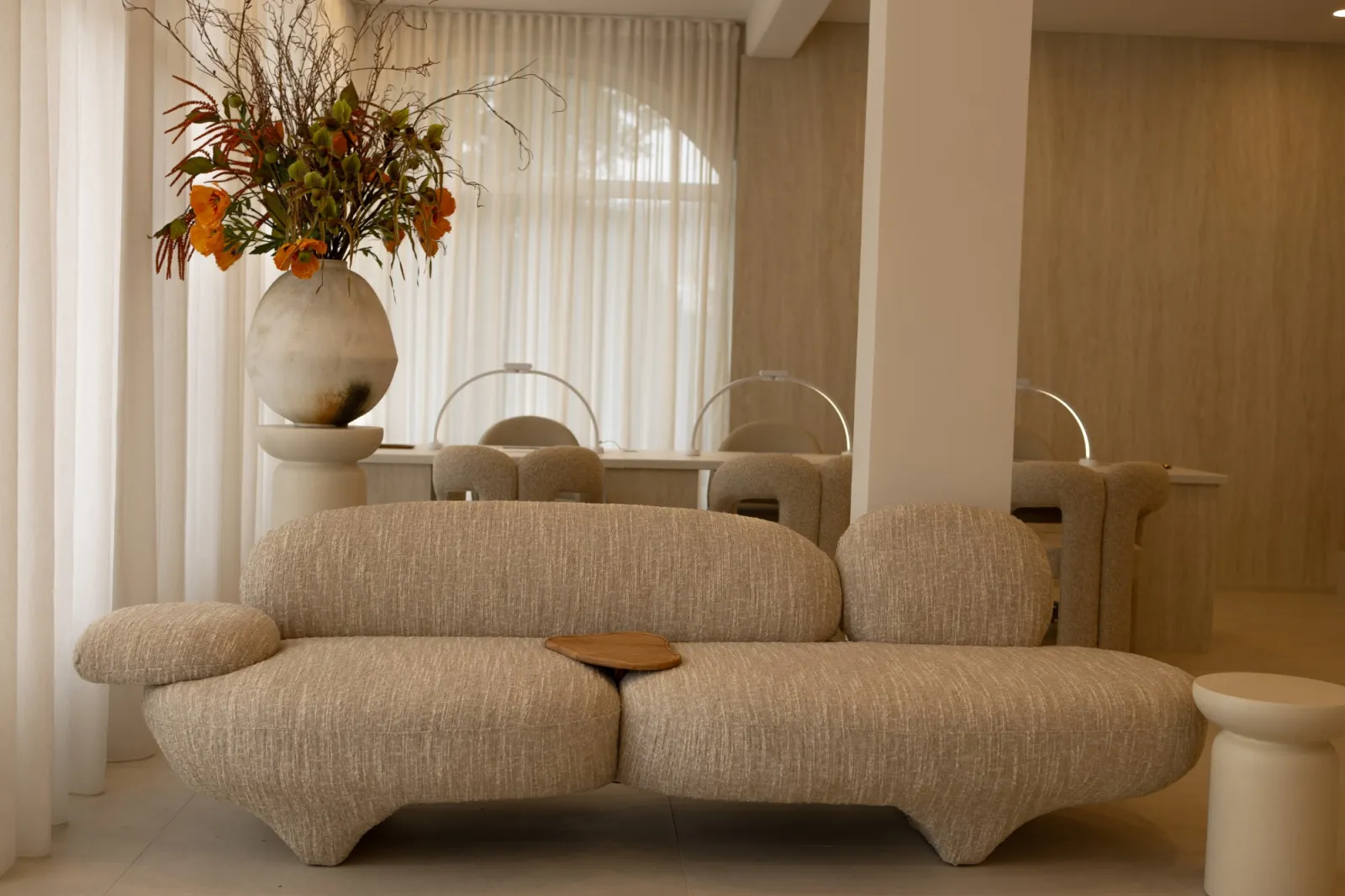 Lounge s mekanom sofom ispred stolova za manikuru